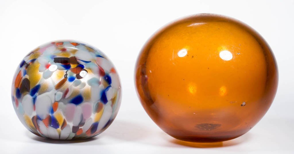ASSORTED BLOWN GLASS DECORATION / COVER BALLS, LOT OF: ASSORTED BLOWN GLASS DECORATION / COVER BALLS, LOT OF TWO, comprising an amber example with rough pontil mark with a 1/4" opening and remnants of plaster, and an art glass example with a silver and go