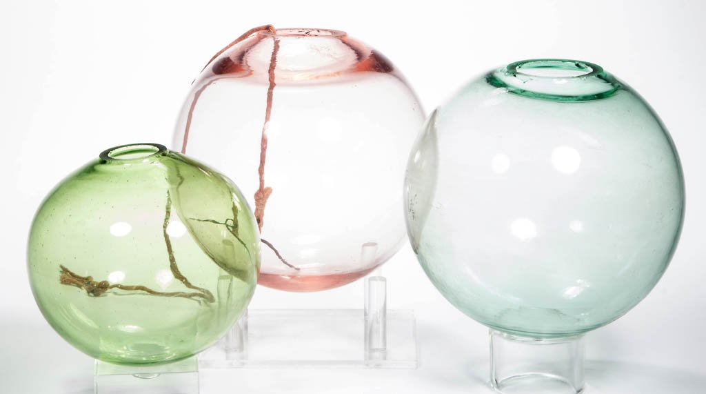 ASSORTED FREE-BLOWN WITCH BALLS, LOT OF THREE: ASSORTED FREE-BLOWN WITCH BALLS, LOT OF THREE, aquamarine, pink and green, each with a polished pontil mark, 1" to 1 1/2" openings. First half 20th century. 4 1/4" to 5" D. Provenance: From the collec