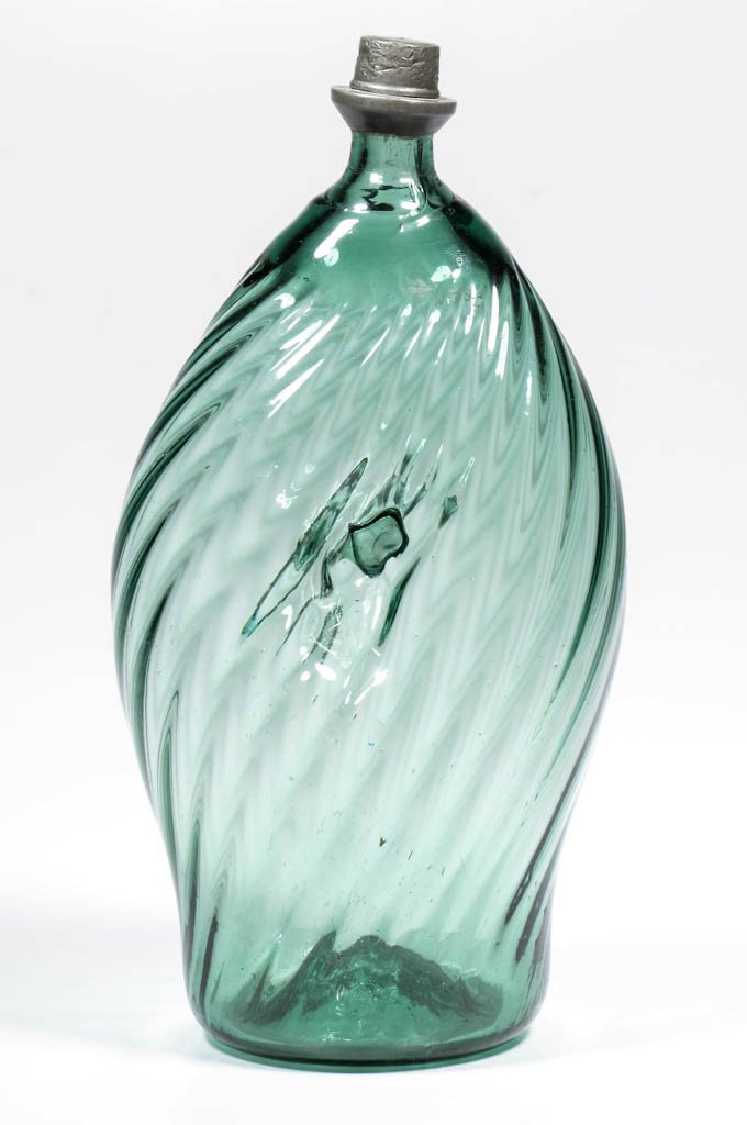 PATTERN-MOLDED ALPINE PINCH-SIDE FLASK / NABELFLASCHE: PATTERN-MOLDED ALPINE PINCH-SIDE FLASK / NABELFLASCHE, medium green, tall flattened ovoid form with pinched sides, molded with 24 ribs swirled to the right, kick-up base with rough pontil mark, origin