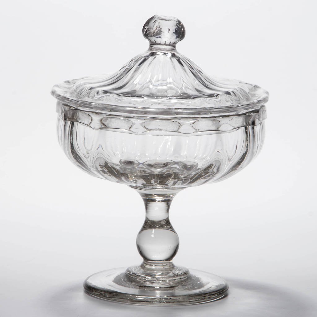PATTERN-MOLDED COVERED SWEETMEAT COMPOTE: PATTERN-MOLDED COVERED SWEETMEAT COMPOTE, colorless, shallow bowl with 14 vertical ribs and a delicate folded rim, raised on an applied baluster-form stem and circular foot, low-dome 20-rib cover with
