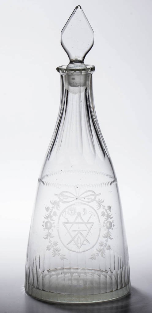 FREE-BLOWN, ENGRAVED AND CUT MASONIC QUART DECANTER: FREE-BLOWN, ENGRAVED AND CUT MASONIC QUART DECANTER, colorless, tapered form featuring a bowknot and wreath enclosing an intricate Masonic emblem within an oval rope frame, cut neck and basal flutes, 