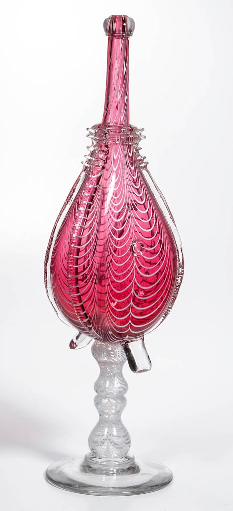 FREE-BLOWN MARBRIE-DECORATED BELLOWS BOTTLE WHIMSY: FREE-BLOWN MARBRIE-DECORATED BELLOWS BOTTLE WHIMSY, cranberry with opaque white loops, body with applied colorless rigaree decorations and two lower handles, raised on a spool-like and baluster-form s