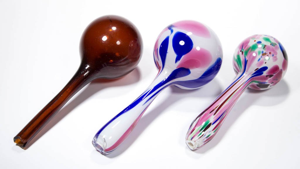 FREE-BLOWN MOTTLED GLASS DARNING BALLS, LOT OF TWO: FREE-BLOWN MOTTLED GLASS DARNING BALLS, LOT OF TWO, opal-cased colorless with blue, green, and pink, each with a rough open-pontil end. Together with a deep amber darner. Three pieces total. Boston & 