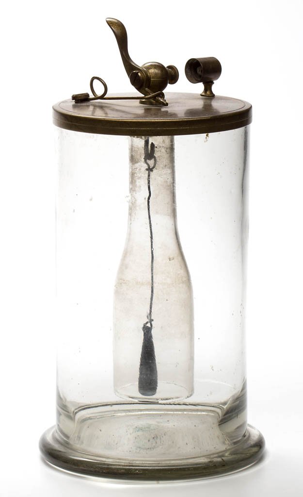 DOBEREINER LAMP / LIGHTER: DOBEREINER LAMP / LIGHTER, colorless, cylinder-form jar with protruding foot, brass drop-in apparatus complete with open-bottle insert and zinc drop. Mid 19th century. 8" H rim, 4 1/4" D. Provenance: 