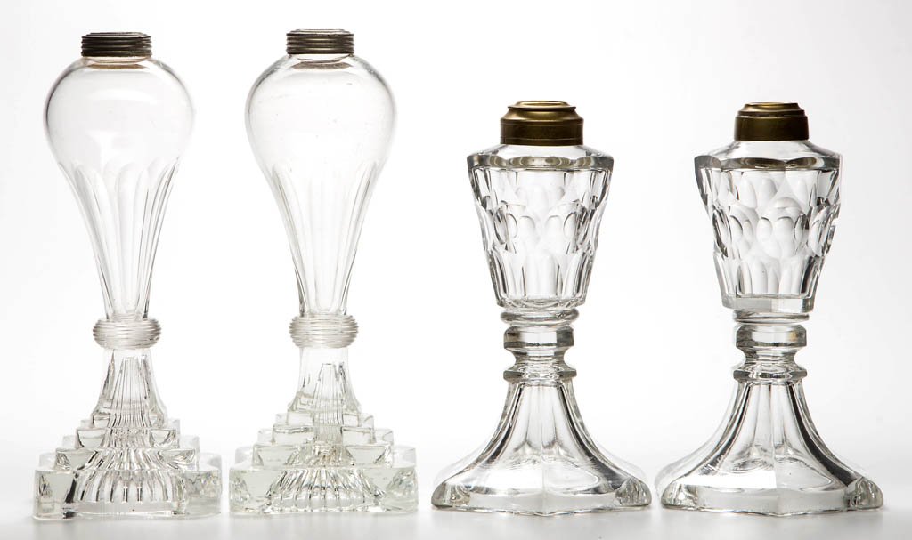 FREE-BLOWN, CUT, AND PRESSED WHALE OIL STAND LAMPS, TWO: FREE-BLOWN, CUT, AND PRESSED WHALE OIL STAND LAMPS, TWO PAIR, colorless, one pair featuring flute-cut bulb-form fonts raised on four-step quatrefoil bases, the other with punty-cut conical fonts raise