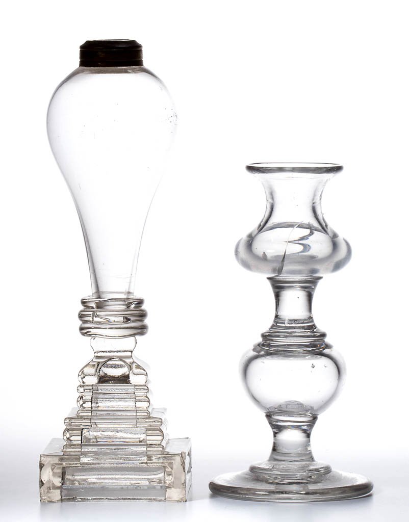FREE-BLOWN AND PRESSED LIGHTING DEVICES, LOT OF TWO: FREE-BLOWN AND PRESSED LIGHTING DEVICES, LOT OF TWO, colorless, comprising a candlestick with urn-form socket and hollow-knop stem, and a whale oil lamp with bulb-form font raised on a stepped square 