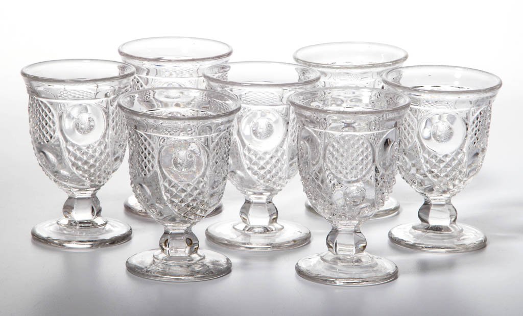 HORN OF PLENTY EGG CUPS, LOT OF SEVEN: HORN OF PLENTY EGG CUPS, LOT OF SEVEN, colorless lead glass, each with a flared rim, five with polished pontil mark. Boston & Sandwich Glass Co. and others. Third quarter 19th century. 3 5/8" to 3 7/8