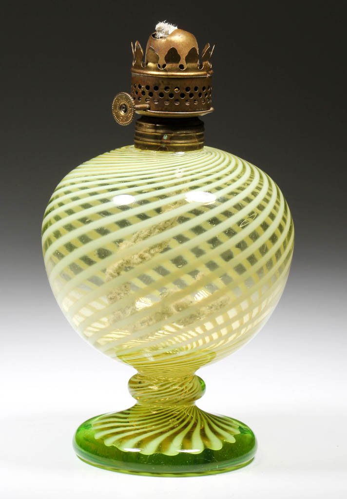 OPALESCENT SWIRL MINIATURE OIL LAMP FONT: OPALESCENT SWIRL MINIATURE OIL LAMP FONT, Vaseline (uranium) with opalescent swirls, raised on a ringed knop and circular foot, period collar. Fitted with period burner. Late 19th/early 20th century. 