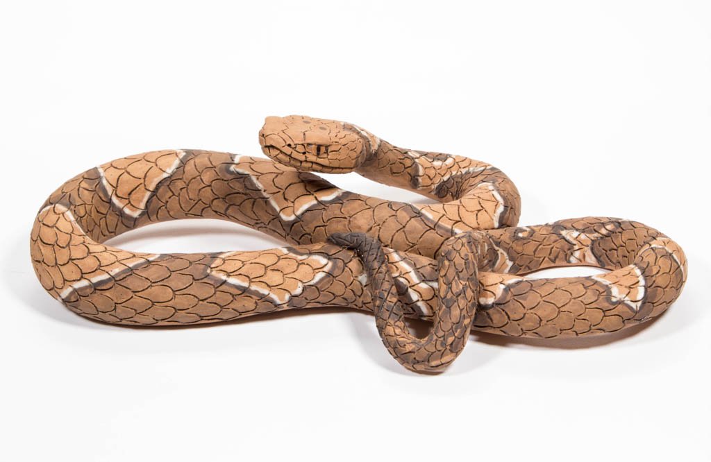 NORTH CAROLINA EARTHENWARE / REDWARE COPPERHEAD SNAKE: NORTH CAROLINA EARTHENWARE / REDWARE COPPERHEAD SNAKE FIGURE, carved scales and painted features, signed "JCK 2012" to underside. 2 7/8" H, 11" L.Provenance: From a North Carolina collection.