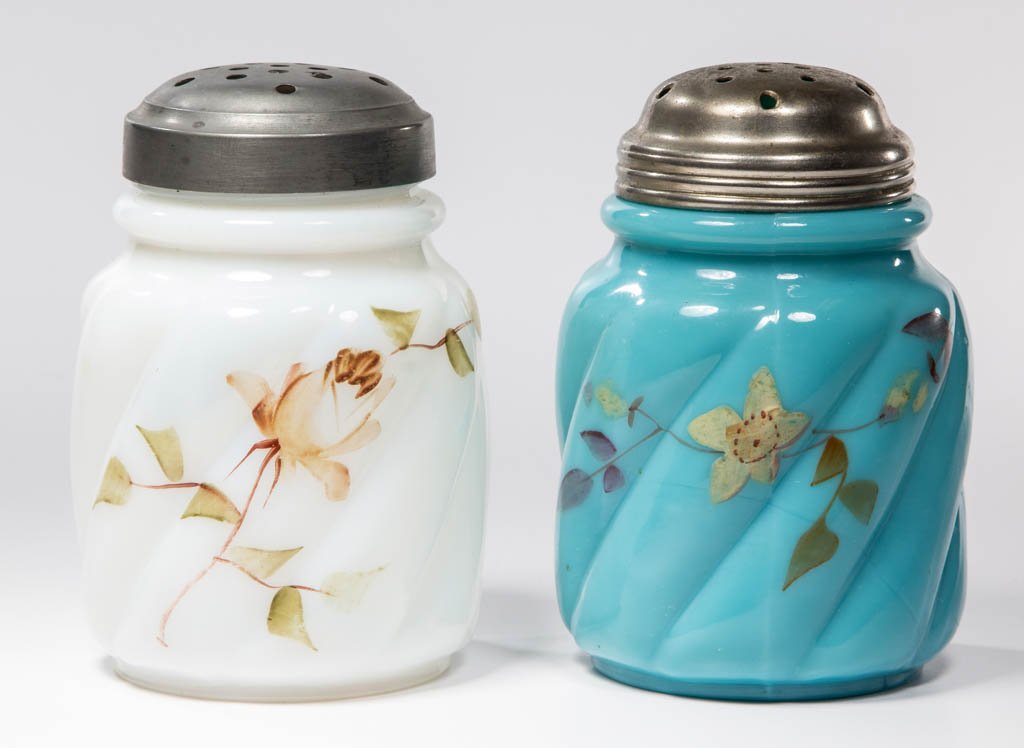 PARIAN SWIRL SUGAR SHAKERS, LOT OF TWO: PARIAN SWIRL SUGAR SHAKERS, LOT OF TWO, opaque blue and opalescent, each with polychrome floral decoration, period lids. Northwood Glass Co. Pattern introduced 1895. 4 3/8" HOA. Provenance: From the c