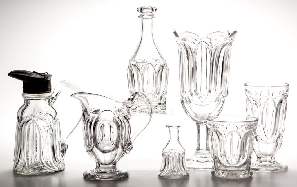 TULIP AND OVAL ARTICLES, LOT OF SEVEN: TULIP AND OVAL ARTICLES, LOT OF SEVEN, colorless lead glass, including an ale glass, tumbler, bitters bottle, and celery vase. Maker unverified. Third quarter 19th century. 3 1/4" to 9 1/8" H. Literat