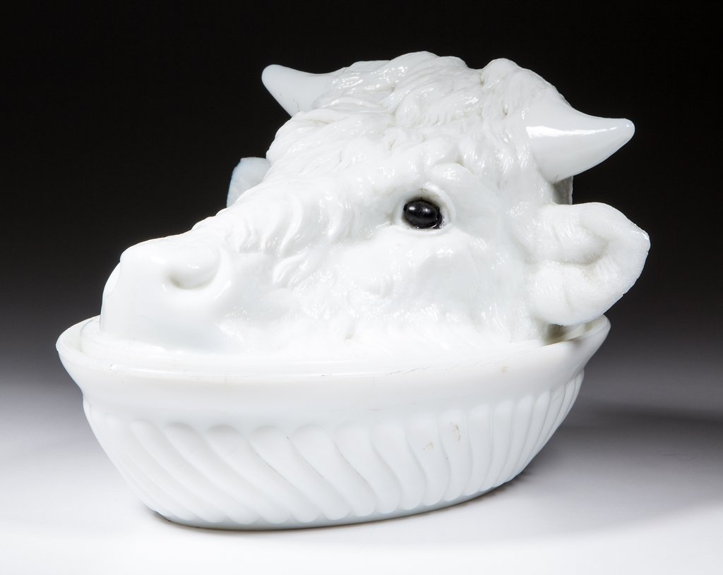 STEER'S HEAD COVERED DISH: STEER'S HEAD COVERED DISH, opaque white, with applied black eyes. Challinor, Taylor & Co. Circa 1885-1893. 5" HOA, 5 1/4" x 7 7/8" base.Literature: Lucas - Tarentum Pattern Glass, p. 85, top left. Fer