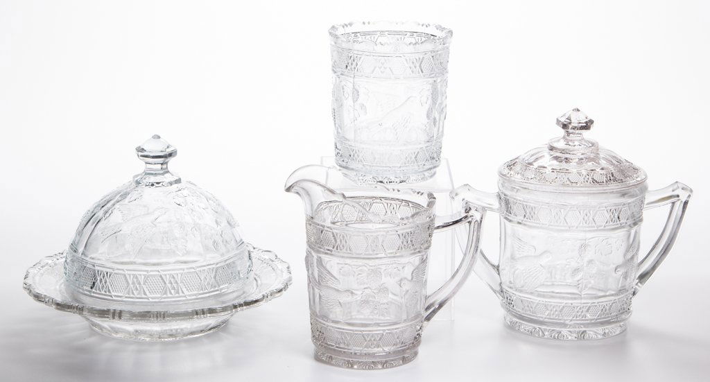 BIRD AND STRAWBERRY / INDIANA NO. 157 FOUR-PIECE TABLE: BIRD AND STRAWBERRY / INDIANA NO. 157 FOUR-PIECE TABLE SET, colorless, comprising a covered butter dish, covered sugar bowl, creamer, and spooner. Indiana Glass Co. Circa 1914. 4" to 6 1/8" HOA.Litera