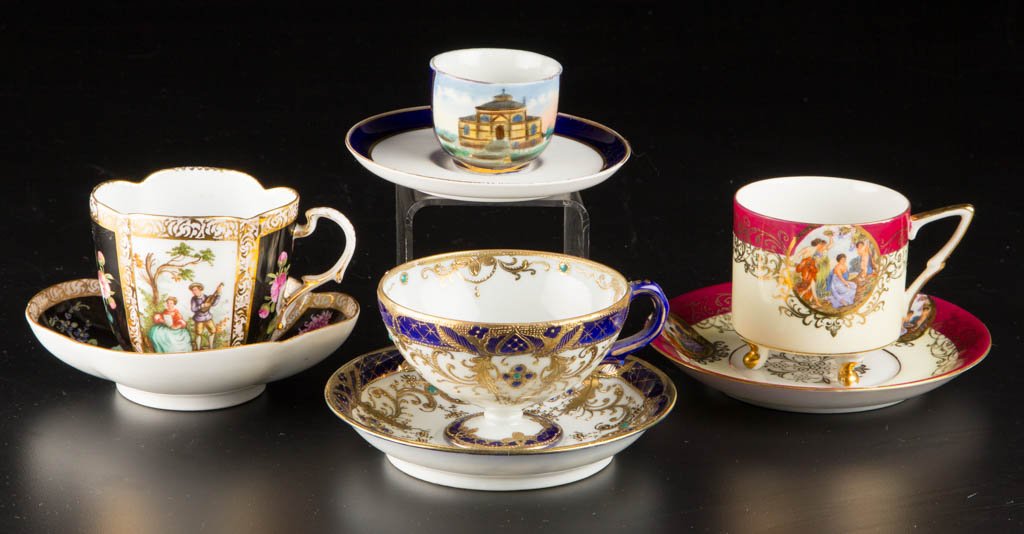 GERMAN PORCELAIN CABINET CUP AND SAUCER SETS, LOT OF: GERMAN PORCELAIN CABINET CUP AND SAUCER SETS, LOT OF FOUR, including a Helena Wolfsohn example featuring alternating painted floral sprays reserved on black panels, with scenes of courtiers, and three