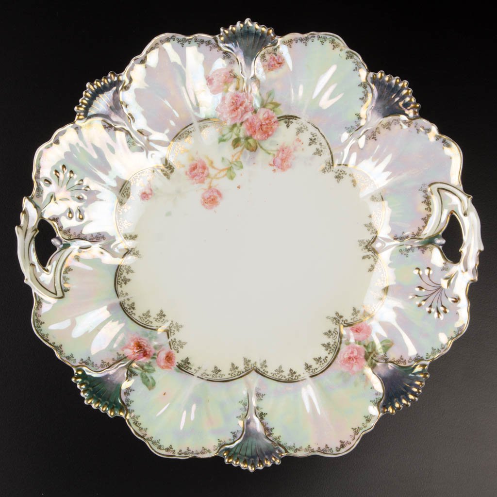 R. S. PRUSSIA PORCELAIN HANDLED CAKE PLATE: R. S. PRUSSIA PORCELAIN HANDLED CAKE PLATE, pearlized finish, with gold-painted highlights, and gold-stenciled decoration, possibly mold 627, with scalloped- and foliate-molded rim, with green Tiffany