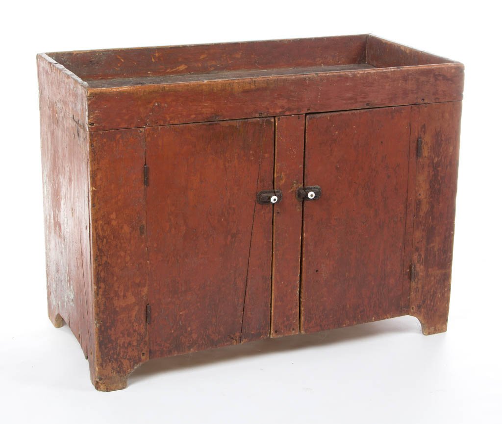 AMERICAN COUNTRY PAINTED PINE DRY SINK: AMERICAN COUNTRY PAINTED PINE DRY SINK, the shallow rectangular well over two hinged plank doors, raised on simple cut-out base and ends. Retains an old red-painted surface, scraped down. Mid 19th cen