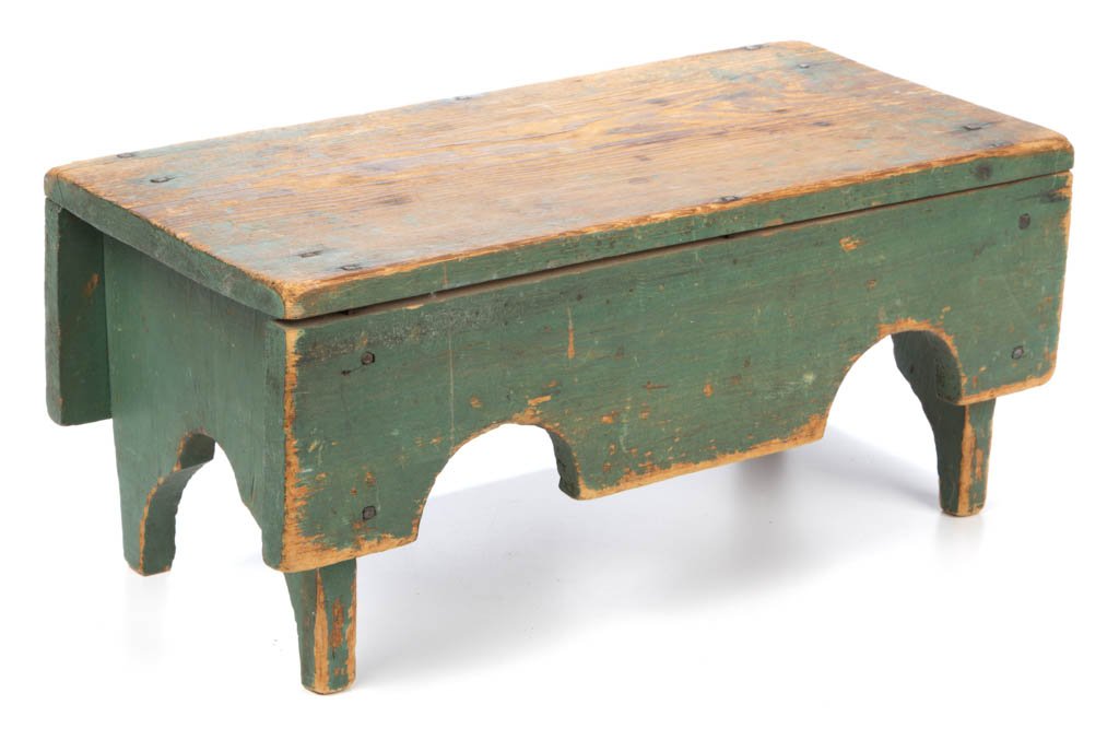 SOUTHERN PAINTED YELLOW PINE FOOTSTOOL: SOUTHERN PAINTED YELLOW PINE FOOTSTOOL, having folky cut-outs to sides and ends, retaining early, possibly original, green-painted surface. Mid 19th century. 8 3/8" H, 8 1/2" W, 18 5/8" L. Provenance:
