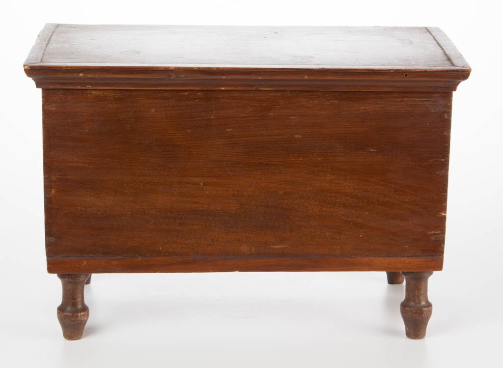 MID-ATLANTIC YELLOW PINE MINIATURE BLANKET CHEST: MID-ATLANTIC YELLOW PINE MINIATURE BLANKET CHEST, hinged lid with applied edge moldings, above a lapped and nailed box, raised on four tall turned walnut feet mortised through the bottom. Refinished s