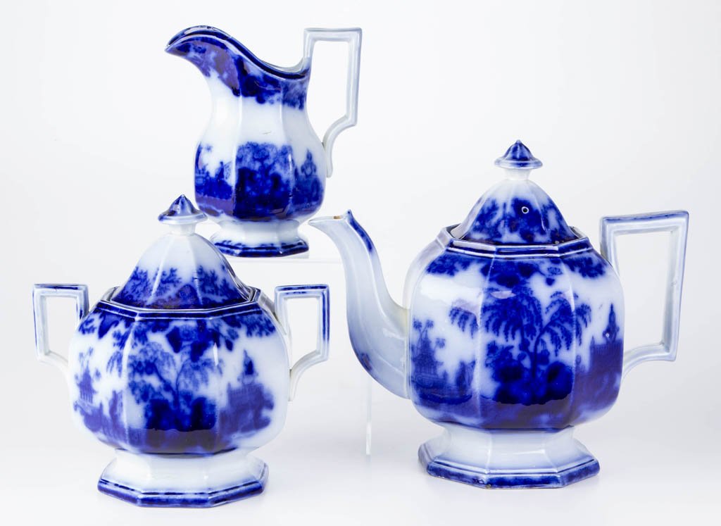 ENGLISH J. & G. ALCOCK IRONSTONE FLOW BLUE "SCINDE": ENGLISH J. & G. ALCOCK IRONSTONE FLOW BLUE "SCINDE" PATTERN ARTICLES, LOT OF THREE, transfer printed, comprising a teapot, covered sugar bowl and covered creamer, all of molded octagonal-panelled form