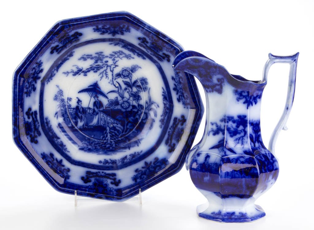 ENGLISH DAVENPORT IRONSTONE FLOW BLUE "AMOY" PATTERN: ENGLISH DAVENPORT IRONSTONE FLOW BLUE "AMOY" PATTERN EWER AND BASIN, transfer printed, the ewer of low, globular, panelled form with long neck under the everted spout and the shouldered, nine-sided wa