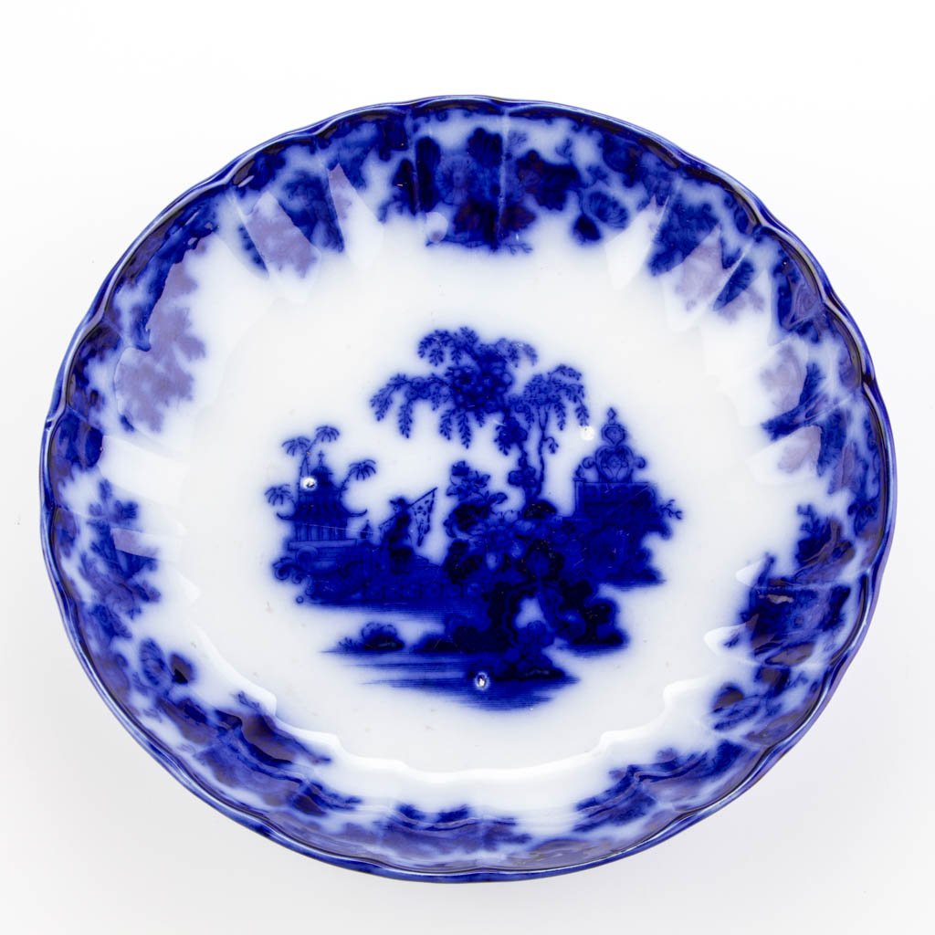 ENGLISH J. & G. ALCOCK IRONSTONE FLOW BLUE "SCINDE": ENGLISH J. & G. ALCOCK IRONSTONE FLOW BLUE "SCINDE" PATTERN SERVING BOWL, transfer printed, of scallop-molded lobed form, the pattern printed to the body below the Asian-style geometric and foliate pa