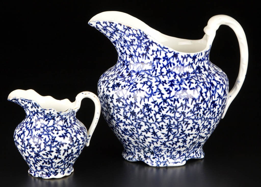 AMERICAN KNOWLES, TAYLOR & KNOWLES IRONSTONE FLOW BLUE: AMERICAN KNOWLES, TAYLOR & KNOWLES IRONSTONE FLOW BLUE PITCHERS, LOT OF TWO, transfer printed, both of lobed, globular form, sheet transfer-printed allover with flowering vines, with gilt lines at rim