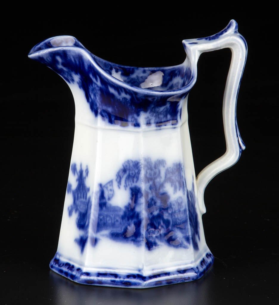 ENGLISH J. & G. ALCOCK IRONSTONE FLOW BLUE "SCINDE": ENGLISH J. & G. ALCOCK IRONSTONE FLOW BLUE "SCINDE" PATTERN PITCHER, transfer printed, of octagonal panel-molded form, with scalloped lip, transfer-printed with the pattern under the Asian-inspired fo
