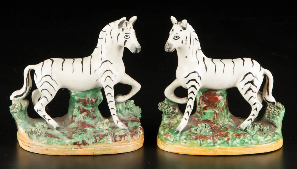 ENGLISH PARR-KENT POTTERY STAFFORDSHIRE PAIR OF ZEBRA: ENGLISH PARR-KENT POTTERY STAFFORDSHIRE PAIR OF ZEBRA FIGURES, each painted with black stripes on white bodies, standing on a grassy mound encrusted with dried clay "grass" painted realistically, on o