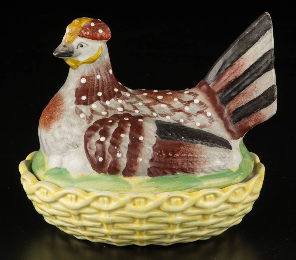 ENGLISH STAFFORDSHIRE POTTERY "NESTING HEN" TUREEN: ENGLISH STAFFORDSHIRE POTTERY "NESTING HEN" TUREEN, the cover modeled as the speckled hen with gray, brown and black feathers, seated on a grassy mound above her eggs, the lower section modeled as a y
