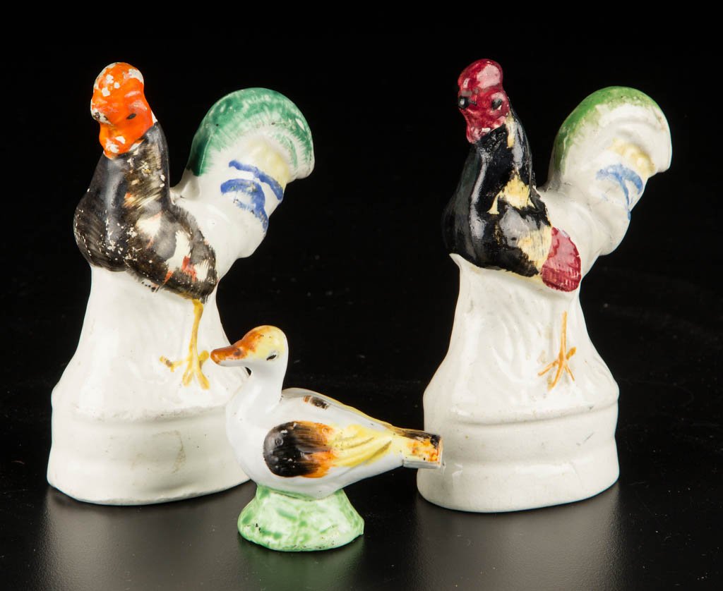 ENGLISH STAFFORDSHIRE POTTERY DUCK FORM WHISTLE AND: ENGLISH STAFFORDSHIRE POTTERY DUCK FORM WHISTLE AND ROOSTER FIGURES, LOT OF THREE, comprising a whistle formed as a duck atop a small, circular green mound, and two roosters, each standing atop waiste
