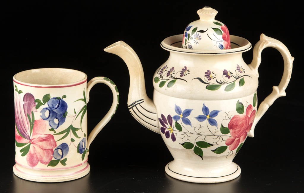 ENGLISH STAFFORDSHIRE POTTERY PEARLWARE ARTICLES, LOT: ENGLISH STAFFORDSHIRE POTTERY PEARLWARE ARTICLES, LOT OF TWO, comprising a tankard of cylindrical form with a molded band to foot and grooved strap handle, painted with bold, stylized florals in under