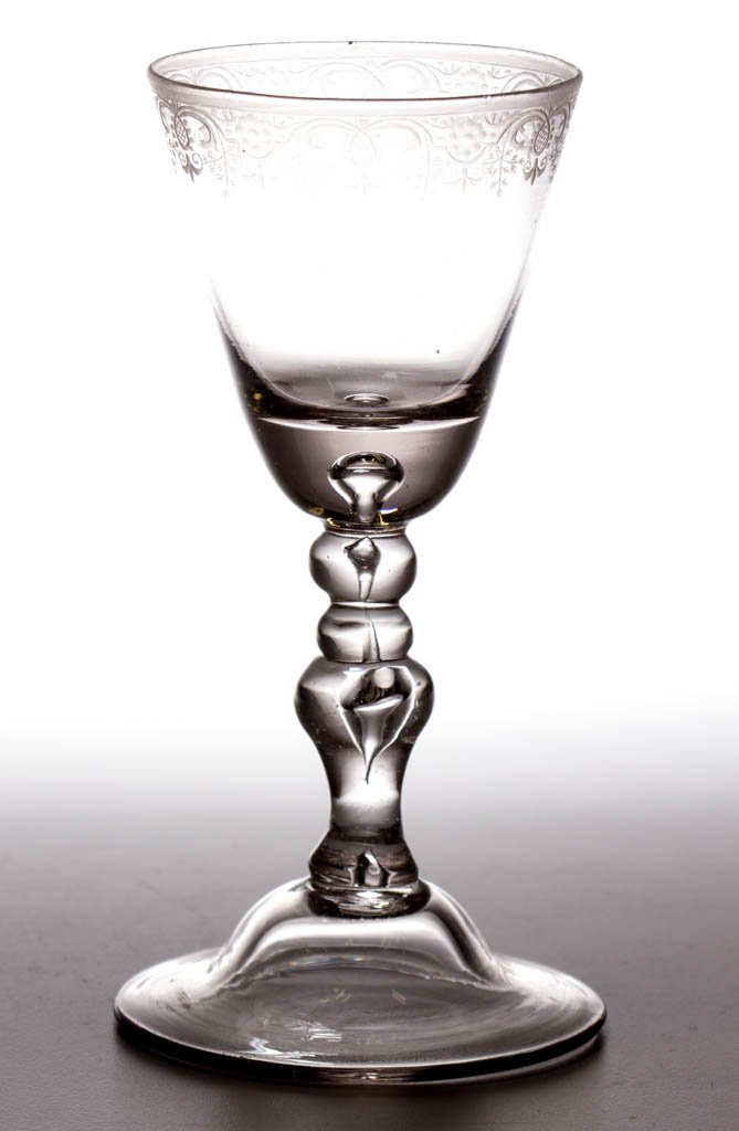 CONTINENTAL FREE-BLOWN AND ENGRAVED BALUSTER-STEM: CONTINENTAL FREE-BLOWN AND ENGRAVED BALUSTER-STEM GOBLET / LARGE WINE GLASS, colorless non-lead glass, round funnel bowl with teared base, delicate engraved foliate and scroll band below rim, raised o
