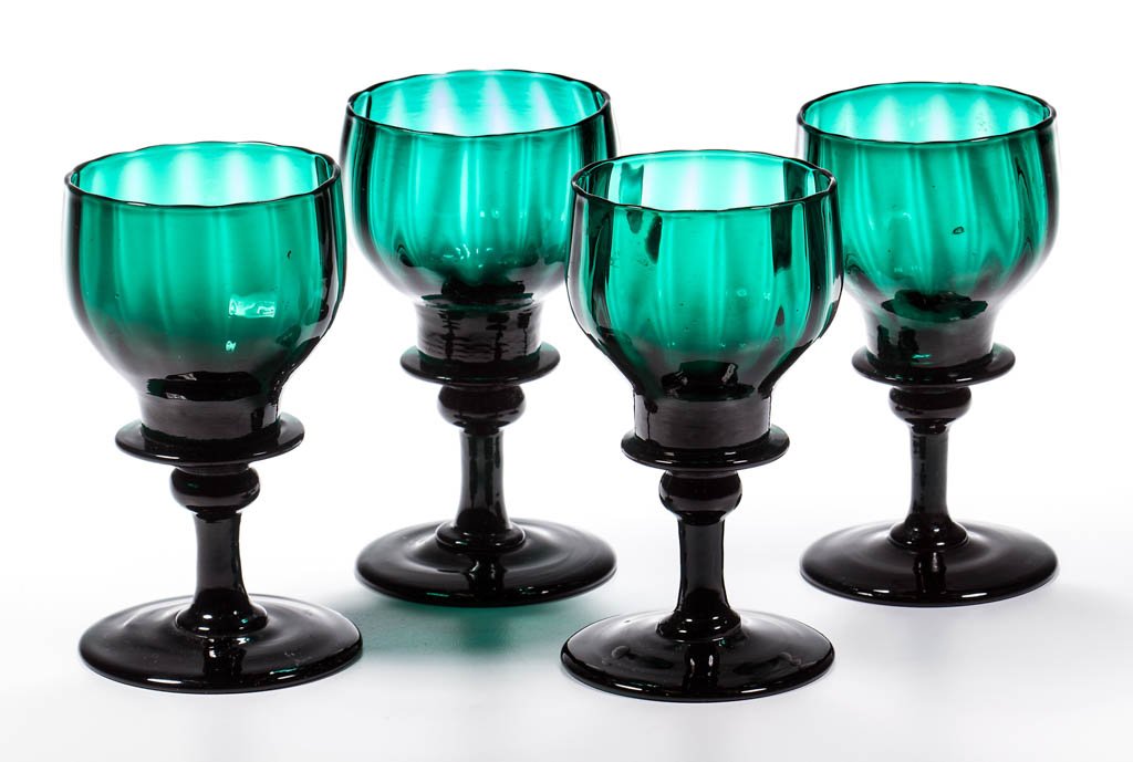 ENGLISH PATTERN-MOLDED COLORED GLASS WINE GLASSES, SET: ENGLISH PATTERN-MOLDED COLORED GLASS WINE GLASSES, SET OF FOUR, deep emerald green lead glass, each ogee bowl with 16 ribs and bladed base, raised on a stem with upper knop, circular foot with rough p