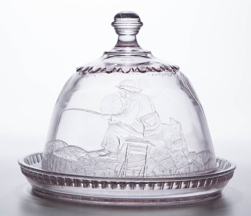 ACTRESS CHEESE DISH: ACTRESS CHEESE DISH, colorless, cover with "The Lone Fisherman," base depicting "Two Dromios". Fourth quarter 19th century. 6 1/2" HOA, 8 1/8" DOA. Provenance: From the collection of Kent and Mary Ste