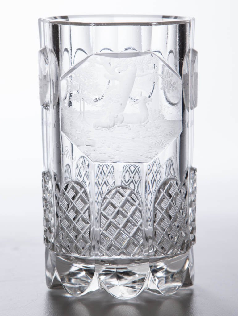 BOHEMIAN ENGRAVED BEAKER: BOHEMIAN ENGRAVED BEAKER, colorless, with engraved raised panels, largest panel depicting a deer and fawn laying under a tree. Third quarter 19th century. 5 3/4" H. Provenance: From the collection of 