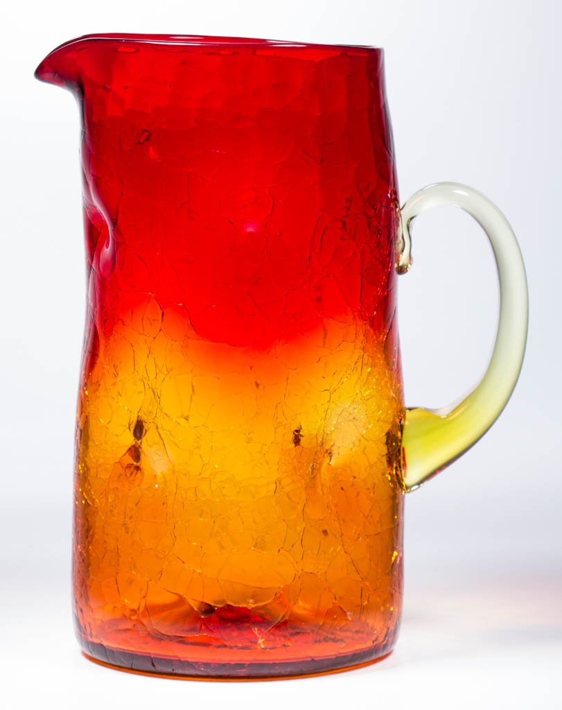 AMBERINA CRACKLE ART GLASS WATER PITCHER: AMBERINA CRACKLE ART GLASS WATER PITCHER, with an applied amber handle, dimpled body, and a rough pontil mark. Probably European. 20th century. 10 3/8" H. Provenance: From the collection of Kent and M