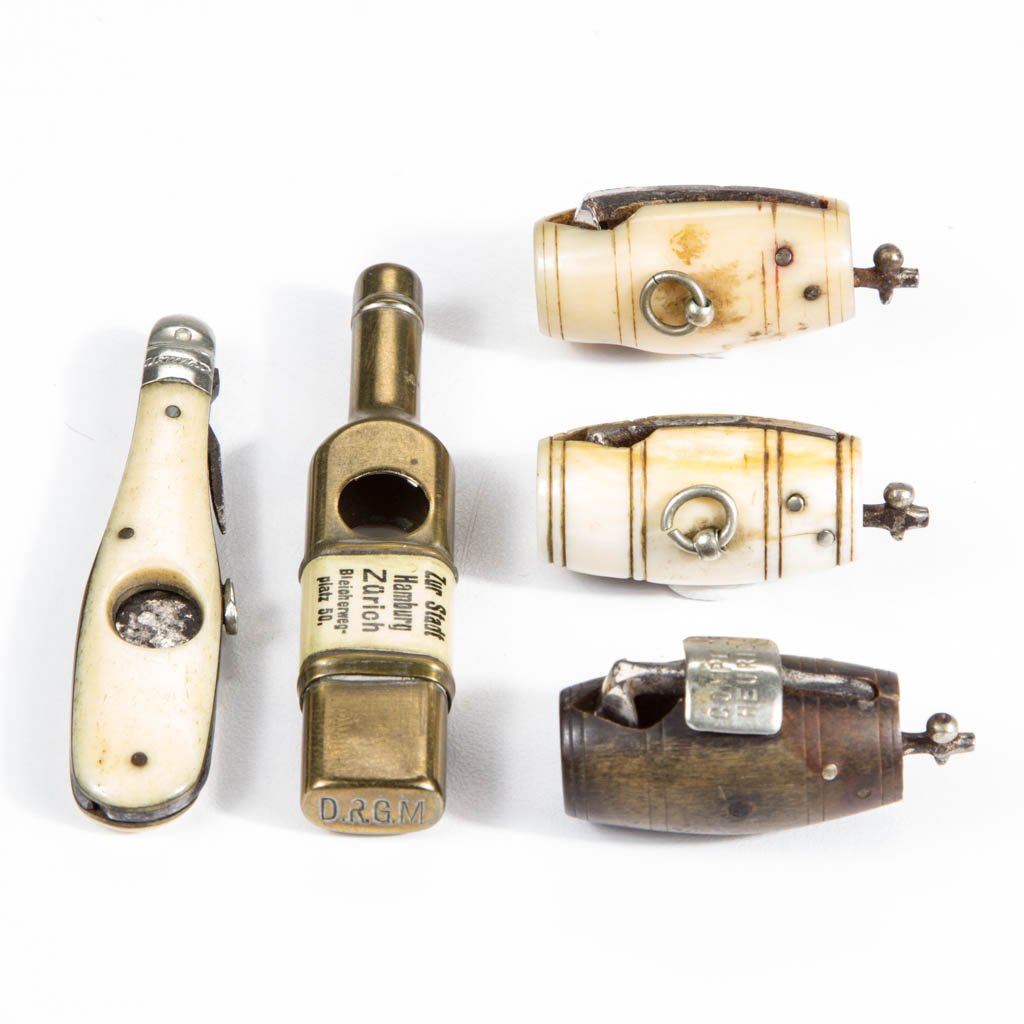 FIGURAL BOTTLE / KEG CIGAR CUTTERS, LOT OF FIVE: FIGURAL BOTTLE / KEG CIGAR CUTTERS, LOT OF FIVE, comprising two bone keg-form examples, a wood keg-form example marked "Compl. Of Heurich", a bottle-form example with bone panels and folding fork/pick