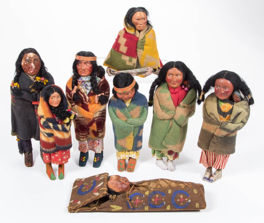NATIVE AMERICAN "SKOOKUM" DOLLS, LOT OF EIGHT: NATIVE AMERICAN "SKOOKUM" DOLLS, LOT OF EIGHT, including two squaw with papoose on back, and a baby doll / papoose on cradle board with hand-painted decoration, three retain original labels. First hal