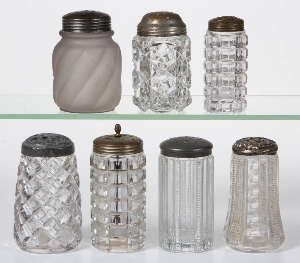 ASSORTED GLASS SUGAR SHAKERS, LOT OF SEVEN: ASSORTED GLASS SUGAR SHAKERS, LOT OF SEVEN, colorless, including a Punty Panel, a frosted Parian Swirl, and a block design example. Various makers. Late 19th/first quarter 20th century. 4 1/8" to 5 1/