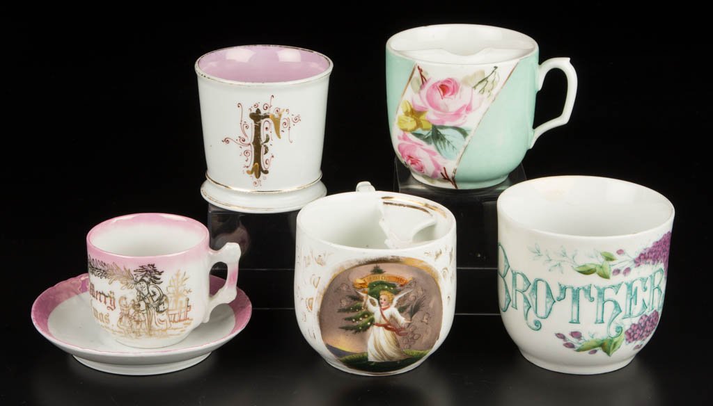 CONTINENTAL PORCELAIN CUPS AND MUGS, LOT OF FIVE: CONTINENTAL PORCELAIN CUPS AND MUGS, LOT OF FIVE, comprising a moustache cup with floral band on pale blue-green ground, another depicting a Christmas / New Year scene in gilt scrolls, a breakfast cup