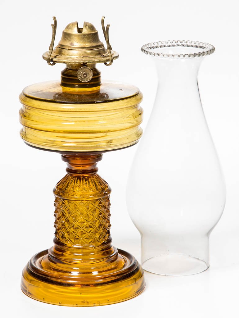 VERA KEROSENE STAND LAMP: VERA KEROSENE STAND LAMP, amber, No. 1 Taplin-Brown collar. Fitted with a Miller No. 1 slip burner and beaded-top chimney. Fourth quarter 19th century. 7 1/4" H to top of collar, 4 1/4" D foot. Litera