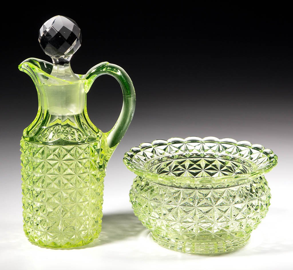 DUNCAN NO. 800 / BAGWEAR ARTICLES, LOT OF TWO: DUNCAN NO. 800 / BAGWEAR ARTICLES, LOT OF TWO, Vaseline (black lighted), comprising a cruet with a cut-facet stopper and a finger bowl. Geo. Duncan & Sons. Circa 1885. 3" and 7 3/4" HOA. Literature: P