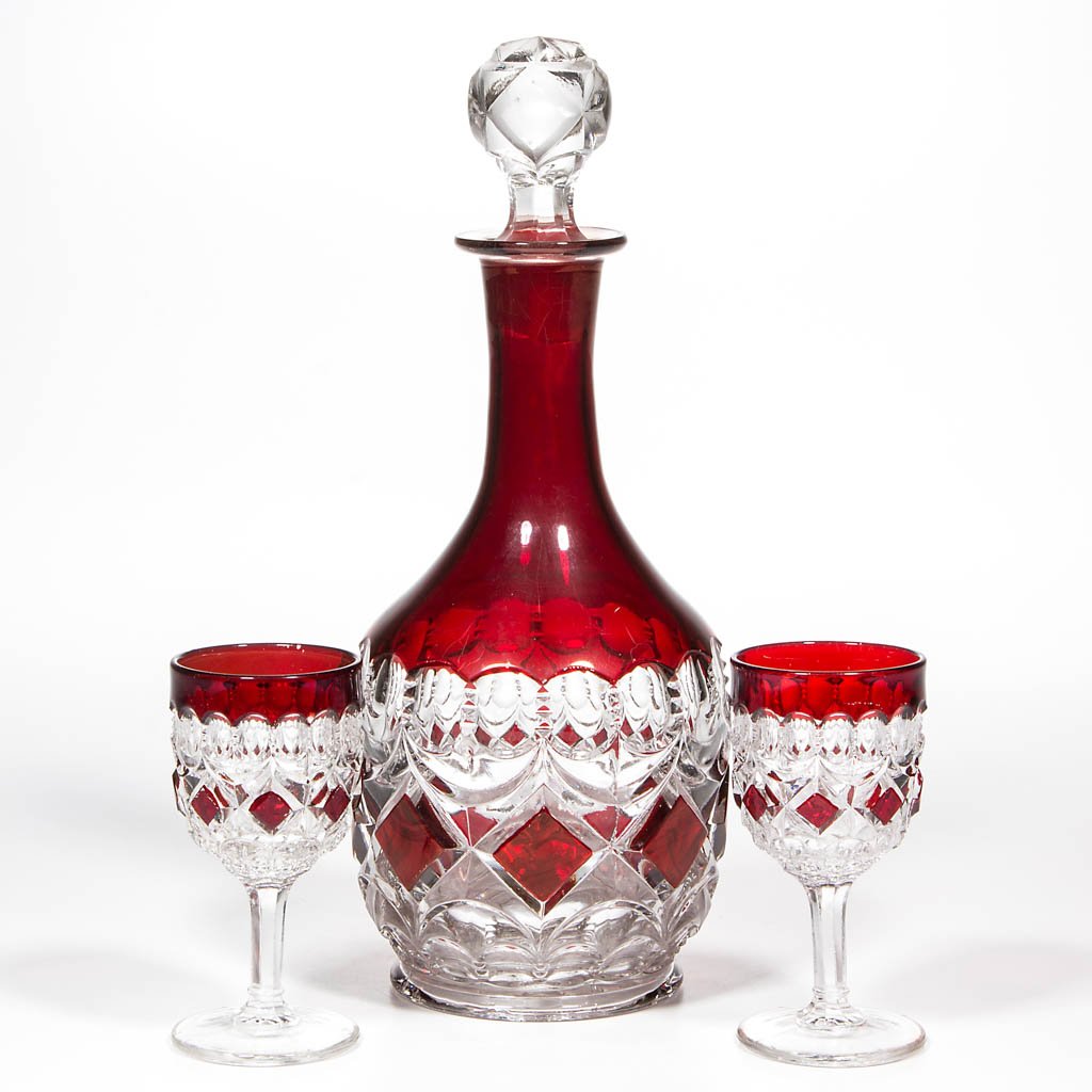 LOOP AND BLOCK - RUBY-STAINED THREE-PIECE WINE SET: LOOP AND BLOCK - RUBY-STAINED THREE-PIECE WINE SET, colorless, comprising a wine decanter and two wines. Probably Thompson Glass Co. Ltd. Circa 1893. 4 1/8" to 10 1/2" HOA. Provenance: From the collec