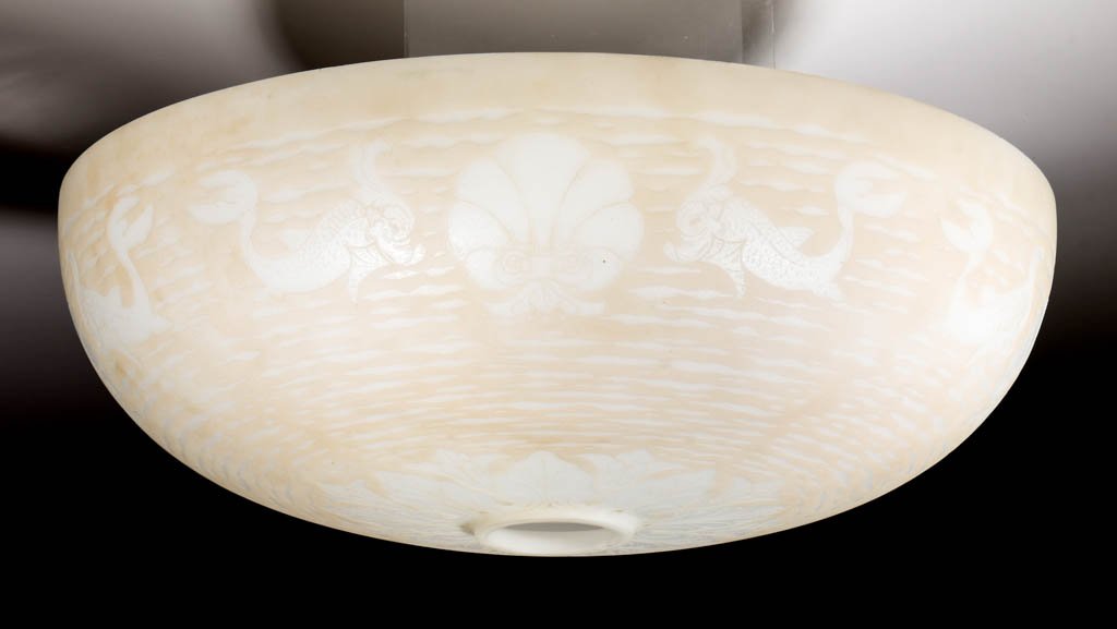 ACID-ETCHED ART GLASS LAMP SHADE: ACID-ETCHED ART GLASS LAMP SHADE, opaque white ground with a pale peach patina, design depicting a band of alternating dolphins and shells with floral decoration surrounding the fitter. Maker unverifi