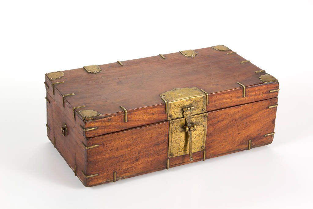 CHINESE CAMPHORWOOD GAME BOX AND PARTIAL MAHJONG SET: CHINESE CAMPHORWOOD GAME BOX AND PARTIAL MAHJONG SET, the box on four triangular block feet, with brass hardware, and internal fitted tray; the partial mahjong set comprising 121 pieces with bone face