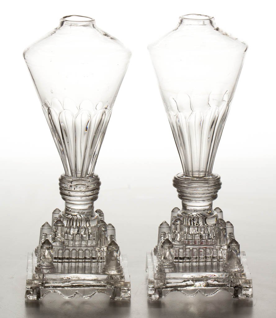 PATTERN-MOLDED AND PRESSED PAIR OF WHALE OIL / FLUID: PATTERN-MOLDED AND PRESSED PAIR OF WHALE OIL / FLUID STAND LAMPS, colorless, each conical font molded with 12 lower elongated arched panels, raised on a complex triple-step square base featuring uprig