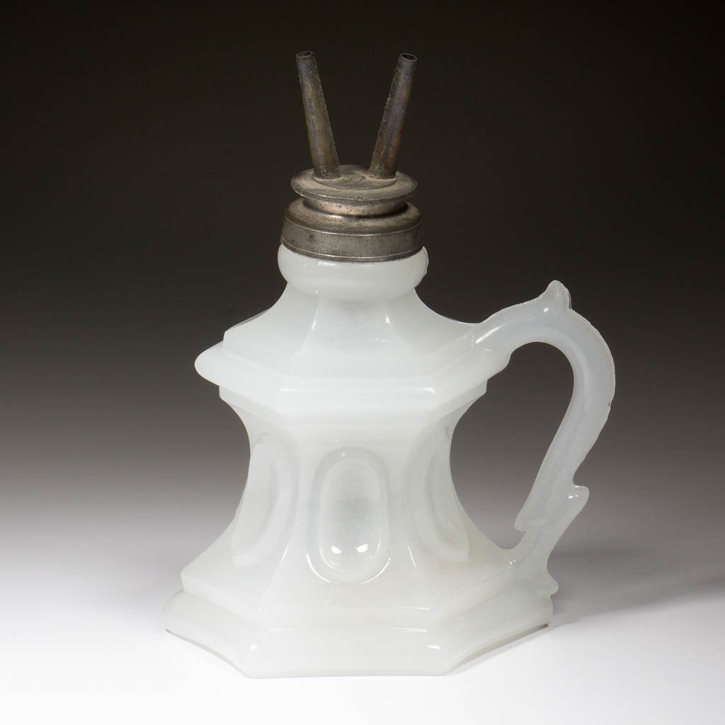PRESSED WAISTED LOOP WHALE OIL / FLUID HAND LAMP: PRESSED WAISTED LOOP WHALE OIL / FLUID HAND LAMP, alabaster/clambroth, molded handle, cut-and-shut scar under base, pewter fine-line collar. Fitted with a double-tube fluid burner. New England. 1840-1