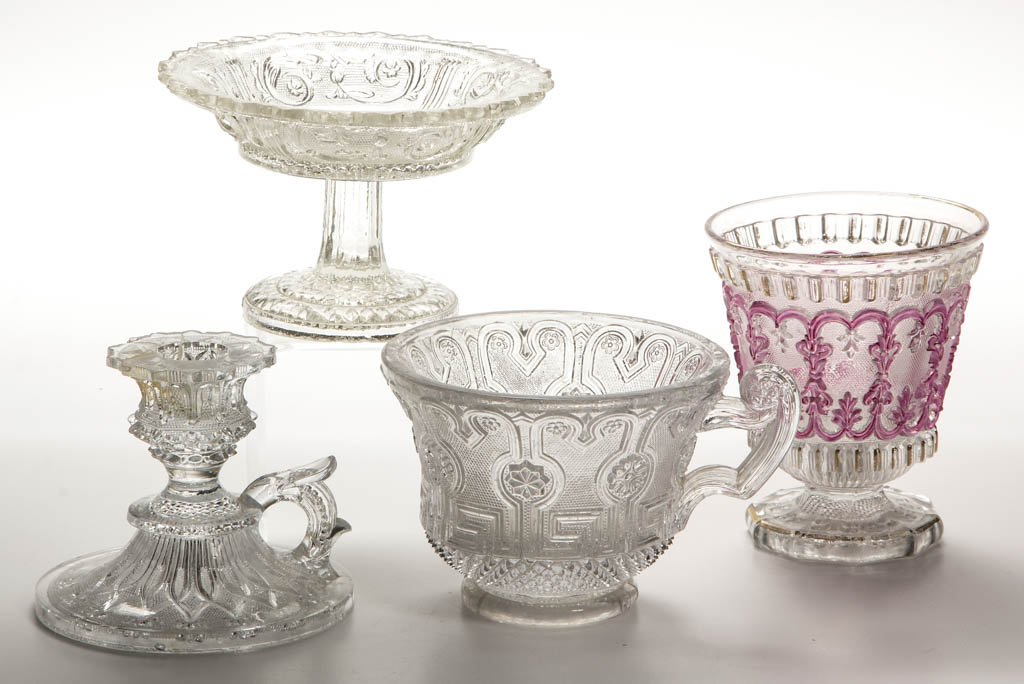 ASSORTED FRENCH PRESSED LACY ARTICLES, LOT OF FOUR: ASSORTED FRENCH PRESSED LACY ARTICLES, LOT OF FOUR, colorless, comprising a compote/nappie waffered to a high foot, a chamberstick, a footed beaker with stained and gilt decoration, and a large cup wi