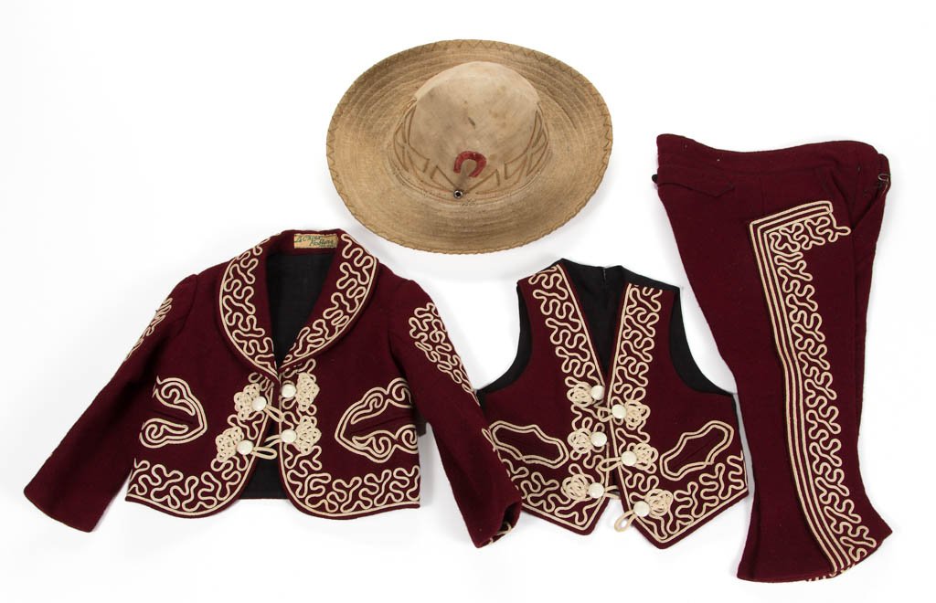 MEXICAN CHILD'S SUIT: MEXICAN CHILD'S SUIT, comprising a wool jacket, vest, and trousers, with cotton hat, each having embroidered ornamentation, with tag having "La China Poblana / PINO SUAREZ". 1900-1920. Trousers 20" L.