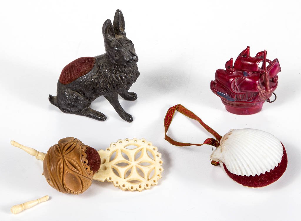ASSORTED MATERIALS FIGURAL SEWING ARTICLES, LOT OF FOUR: ASSORTED MATERIALS FIGURAL SEWING ARTICLES, LOT OF FOUR, comprising three pin cushions with original burgundy red velvet fabric, including a cast metal rabbit, a souvenir shell, and a carved tagua nut